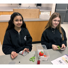 Students displaying their sewing work