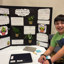 Student exploring research on how words and sound impact plant growth.