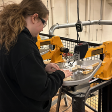 Student working with power tool to create tool.