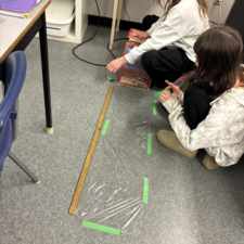 Students measure friction on varying surfaces.