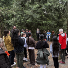 Guest Leyton Schnellert in forest talking with students.